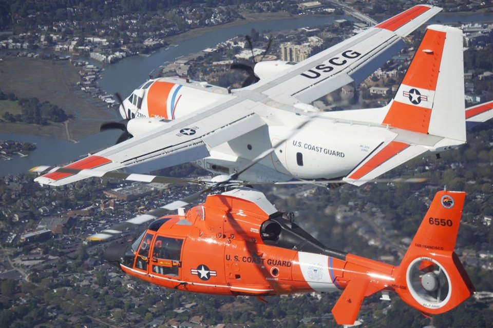 Coast Guard fixed-wing aircraft and MH-65 Dolphin helicopter flying in formation